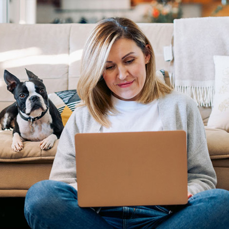 Woman working on laptop with dog