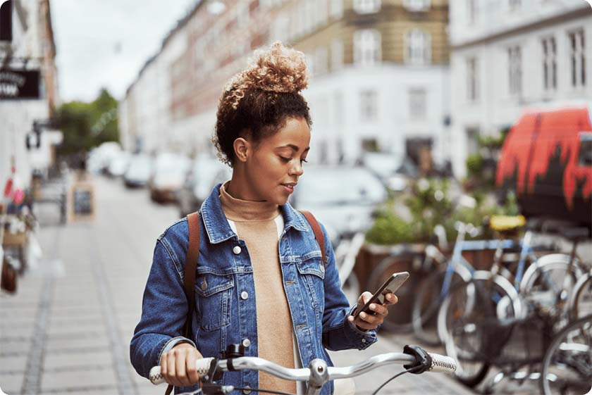 Woman on a bike looking at phone